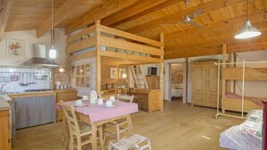 A cozy, rustic cabin with a dining area, kitchen, and bunk beds. - Paradiso by Interhome (Perugia)