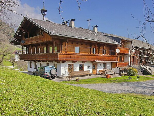 A traditional wooden chalet with a sloped roof, a balcony, and a parked car in front. - Untererhof by Interhome (Fügen)