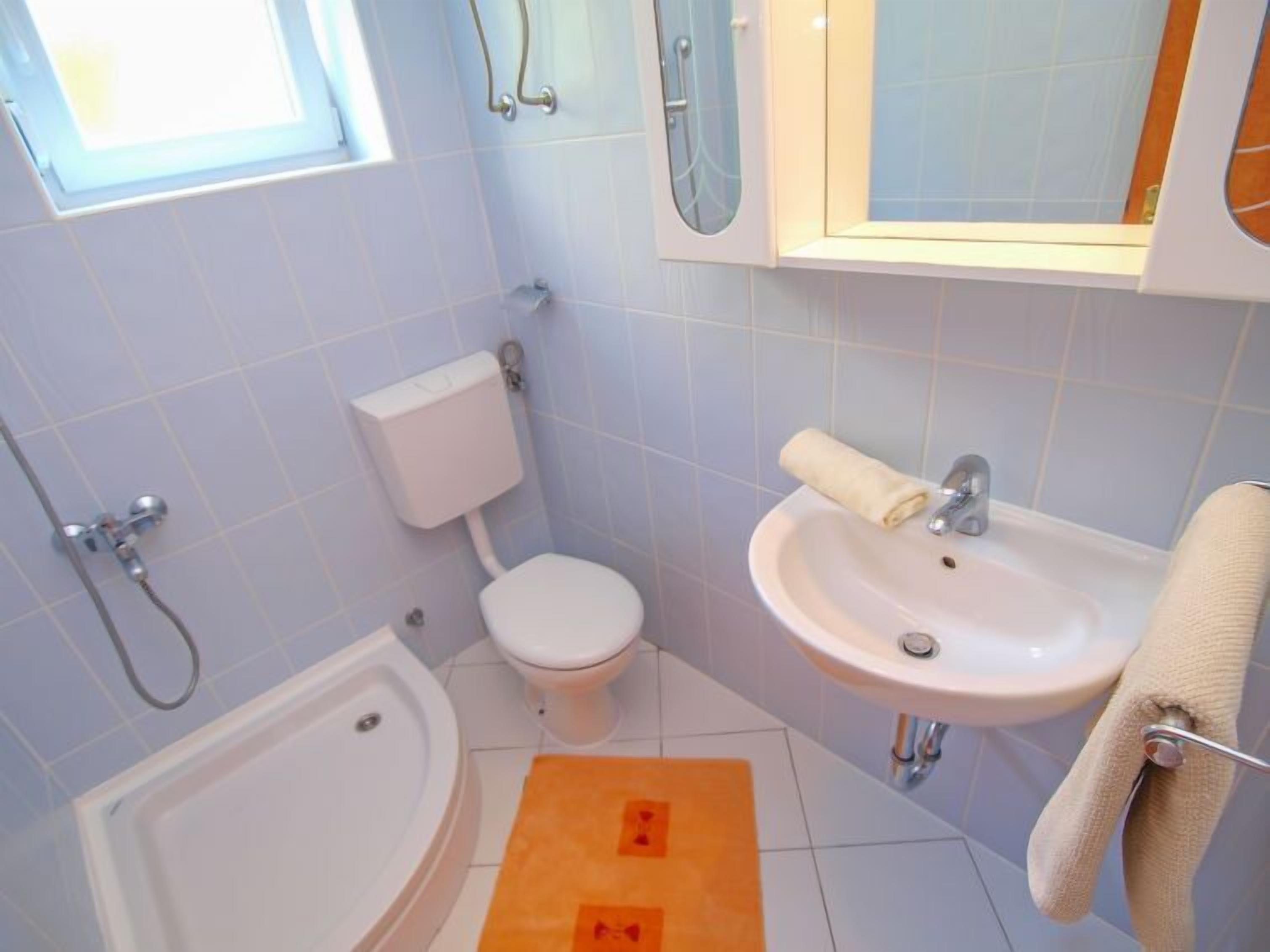 A bathroom with a toilet, sink, and bathtub.