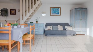 A modern living room with a dining area, a staircase, and a large wardrobe. - Les Jardins du Barcarès by Interhome (Le Barcarès)