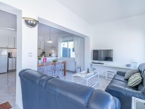 Una sala de estar moderna con un sofá, una mesa de centro y un televisor.