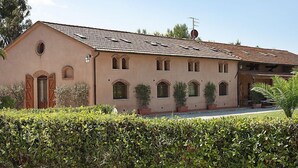 A two-story building with a tiled roof, multiple windows, and a satellite dish. - Le Capanne I by Interhome (Grosseto)