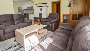 Ein Wohnzimmer mit zwei Sofas, einem Couchtisch und einer Küche im Hintergrund.