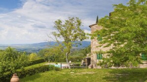 Ein Steinhaus mit Pool und Blick ins Grüne.