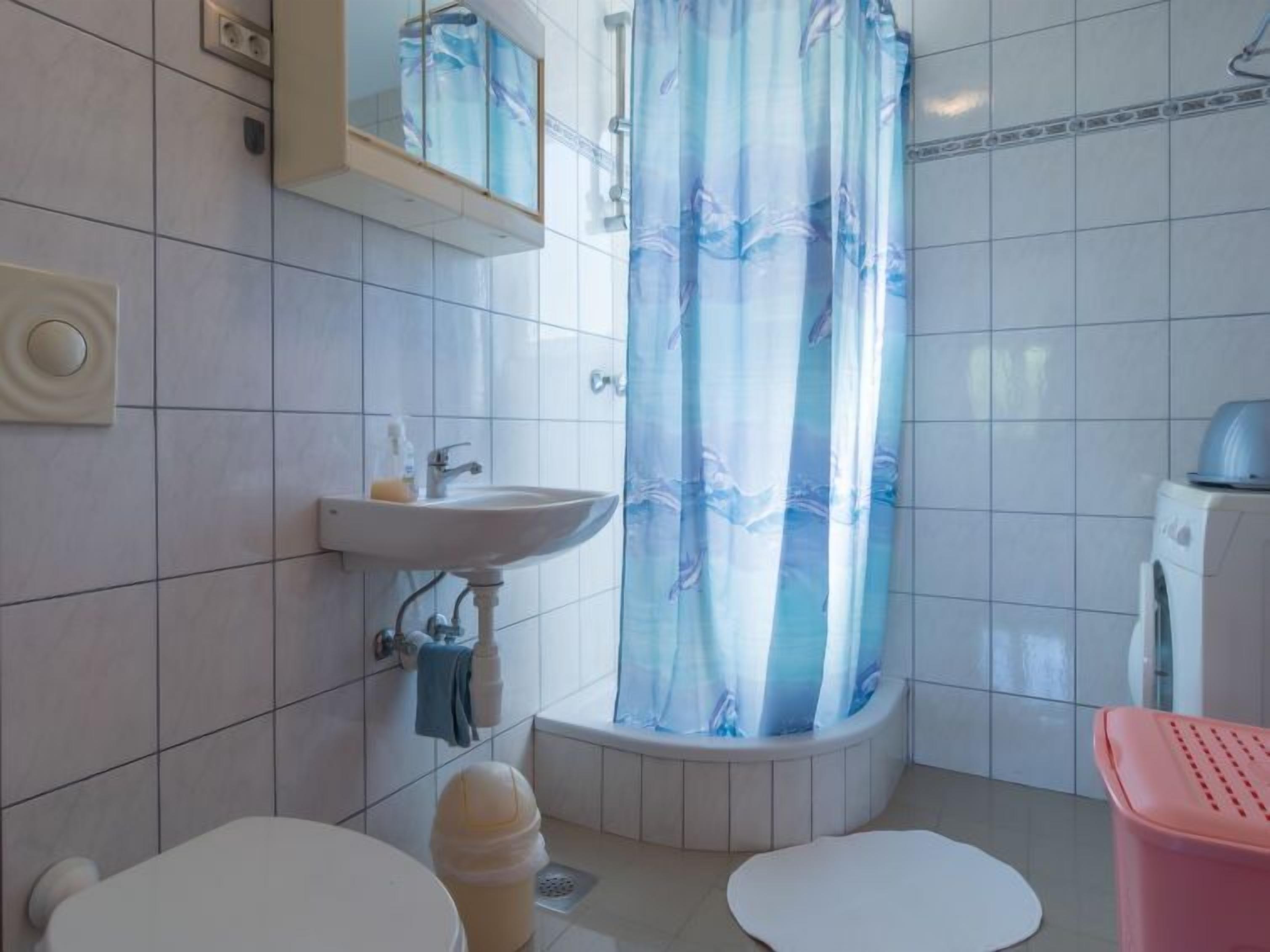 Een badkamer met een wastafel, toilet en douchegordijn.