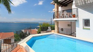 A two-story building with a swimming pool, a balcony with outdoor furniture, and a view of the sea. - Joan Sarda by Interhome (Roses)