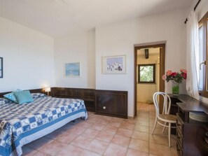 Une chambre à coucher avec un lit, une chaise, un bureau et une fenêtre.