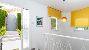 A modern interior with a staircase leading to a balcony, a door with a glass panel, and a painting on the wall. - Delfines by Interhome (Benajarafe)