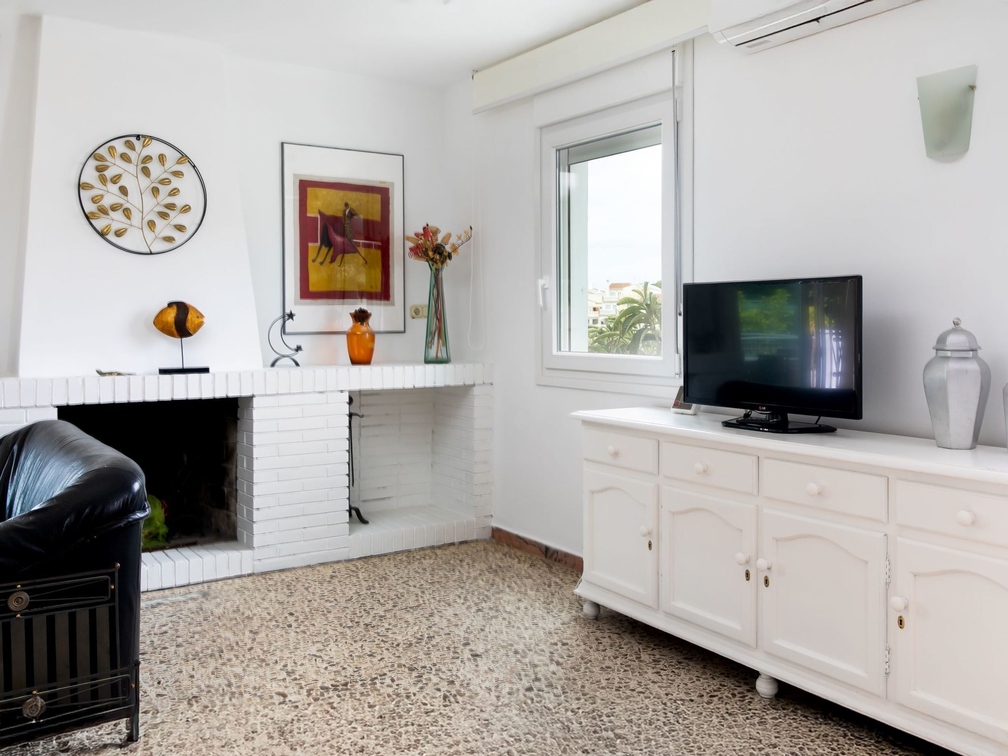 A modern living room with a fireplace, a television, and a white cabinet.