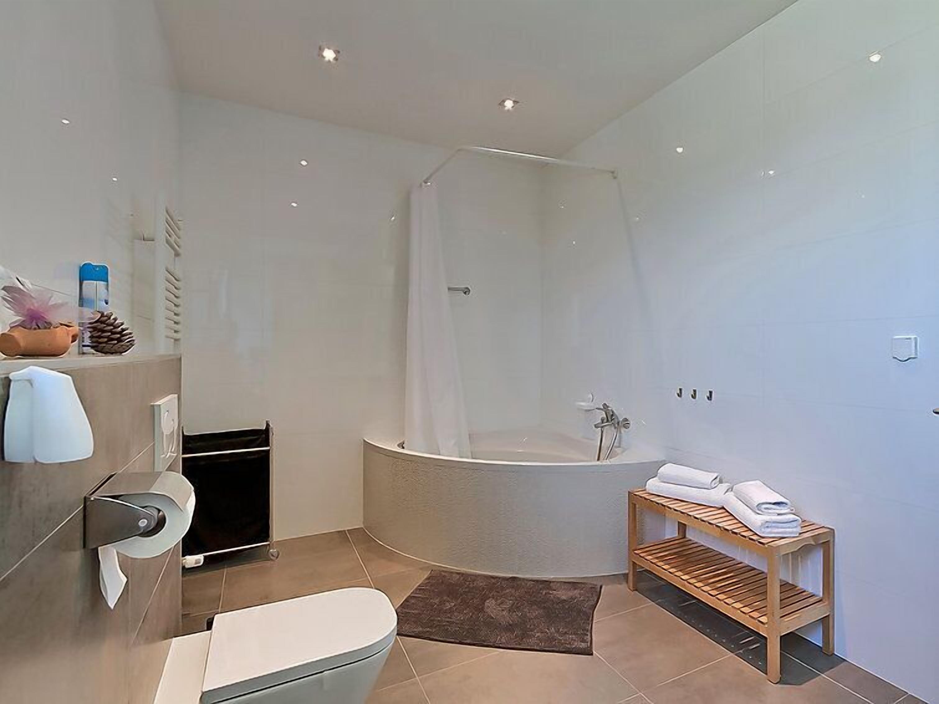 A modern bathroom with a freestanding bathtub, a toilet, and a shower enclosure.