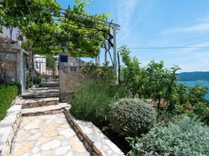 A stone staircase leading to a building with a view of the sea.