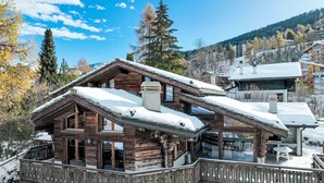 A wooden chalet with a balcony and a covered outdoor seating area, surrounded by snow-covered trees and mountains. - Belle Vue by Interhome (Nendaz)