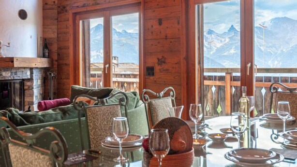 A cozy dining area with a mountain view, wooden walls, and a fireplace. - Belle Vue by Interhome (Nendaz)