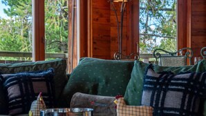 A cozy cabin interior with a wooden table, a metal bowl, and plaid-patterned cushions. - Belle Vue by Interhome (Nendaz)