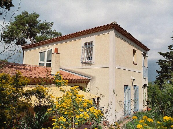 A two-story building with a tiled roof, a balcony with metal railings, and a window with bars. - La Cigale by Interhome (Avignon)