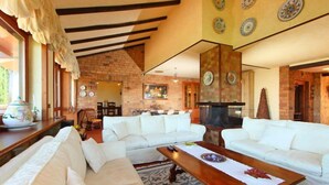 A spacious living area with white sofas, a wooden coffee table, and a fireplace. - Villa Mina by Interhome (Frascati)