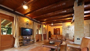 A cozy living room with a stone fireplace, leather sofas, and a television. - Villa Mina by Interhome (Frascati)