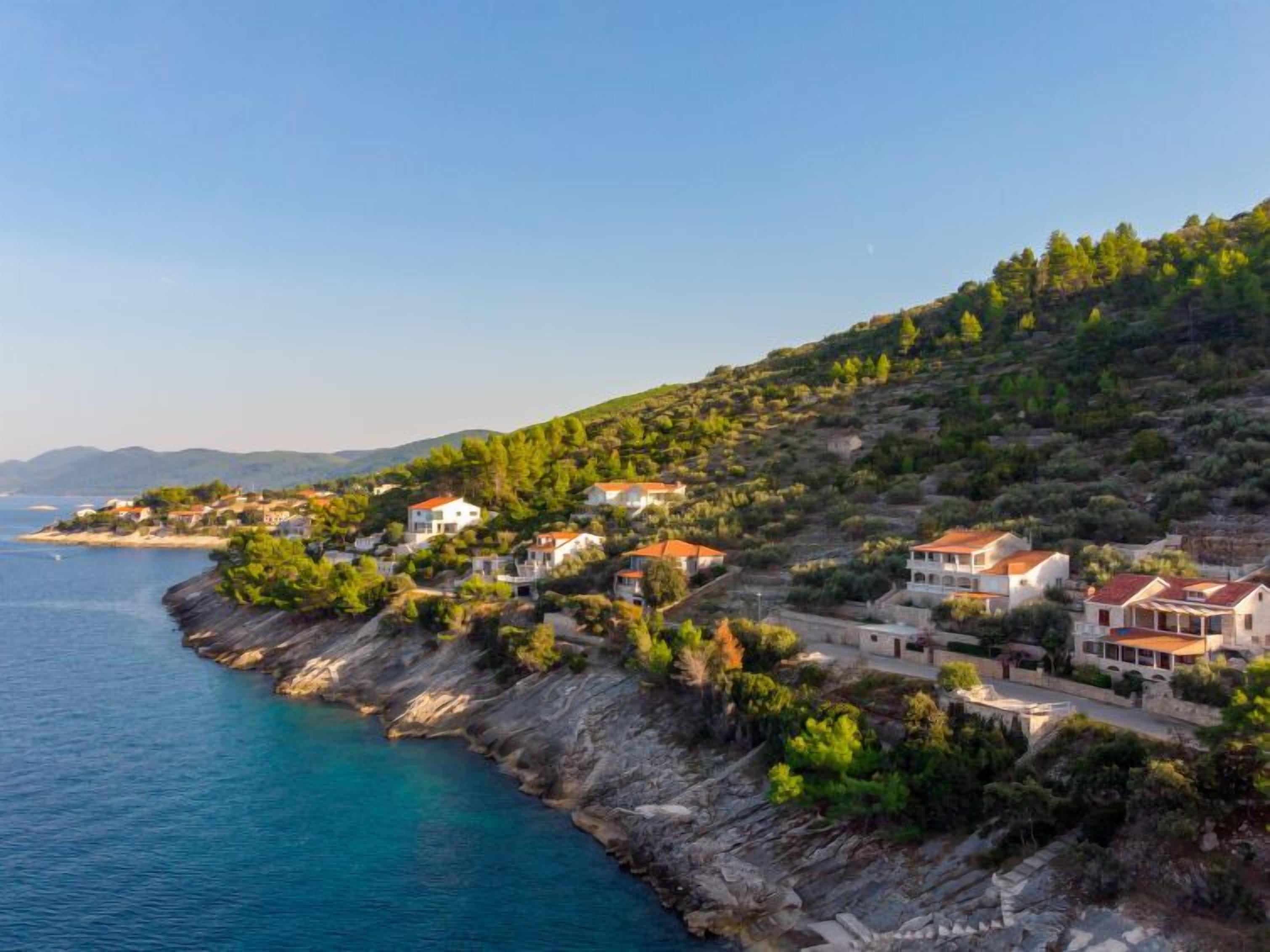 A coastal village with houses on a hillside overlooking the sea.