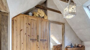 A rustic attic room with wooden beams, a large wooden wardrobe, and a hanging lantern. - Moja Mała Toskania by Interhome (Cisowa)
