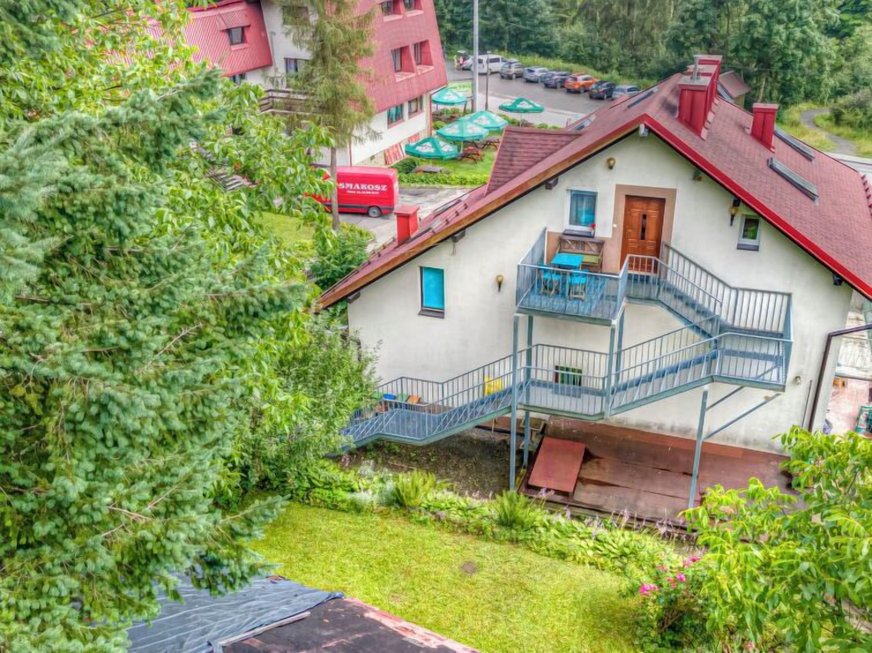 Une maison à deux étages dotée d’un balcon et d’un escalier menant à l’étage supérieur.