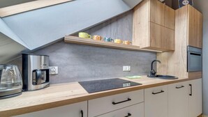 A modern kitchen with a skylight, a coffee maker, a sink, and wooden cabinets. - Kubaczka by Interhome (Wisla)