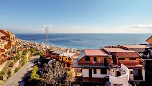 Une ville côtière avec des bâtiments qui bordent la rue et une vue sur la mer.
