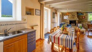 Una cocina con encimera de madera, un fregadero y una zona de comedor con mantel a rayas.