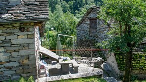 Un edificio de piedra con una escalera de piedra que lleva a una puerta de madera.