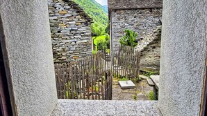 Un edificio de piedra con una cerca de madera y un camino de piedra que lleva a una puerta.