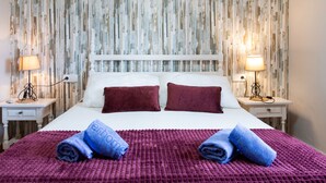 A hotel room with a bed, two nightstands, a white headboard, and a textured wall. - Villa Montemar by Interhome (Nerja)