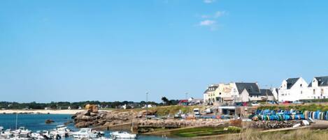 A coastal town with a marina, white buildings, and a clear blue sky.