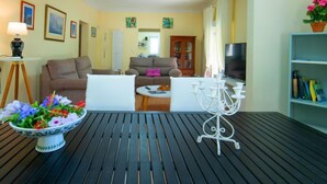 A living room with a sofa, a coffee table, a TV, and a bookshelf. - Vacation home Pedro by Interhome (Albir)