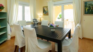 A dining area with a black table, white chairs, and a flower centerpiece. - Vacation home Pedro by Interhome (Albir)