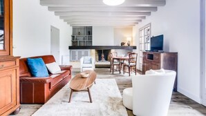 A spacious living room with a fireplace, a dining area, and a kitchen. - Mauriac by Interhome (Capbreton)