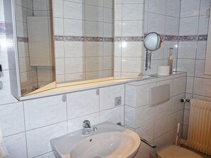 A bathroom with a sink, mirror, and toilet.