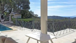 Un patio con piscina, area salotto all'aperto e vista sul paesaggio.