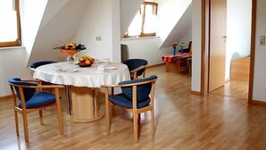 A dining area with a round table, blue upholstered chairs, and a white tablecloth. - Dieboldshof by Interhome (Ichenheim)