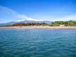 A beach with a mountain in the background. - Apartment Clara by Interhome (Mascali)