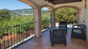 A covered outdoor area with stone arches, a tiled floor, and a view of a mountainous landscape. - Les Mines by Interhome (Selva)