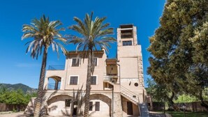 A two-story building with a central tower, arched doorways, and a staircase leading to the upper level. - Les Mines by Interhome (Selva)