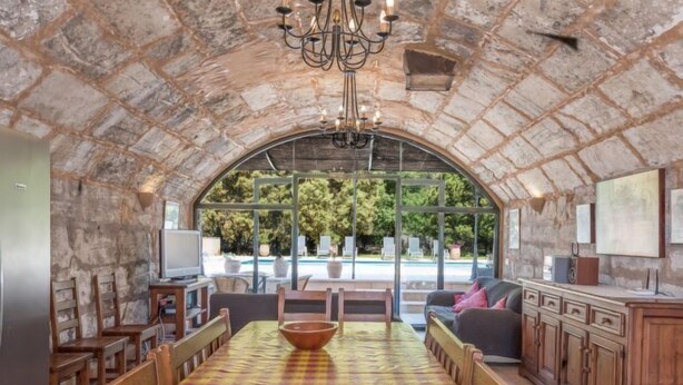 A spacious room with a checkered floor, a pool view, and a stone arch ceiling. - Les Mines by Interhome (Selva)