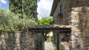 A stone building with a rustic entrance, potted plants, and a stone pathway leading to a door marked with numbers 147 and 431.