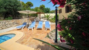 A pool area with lounge chairs and a pergola.