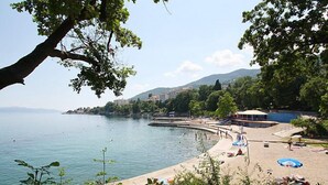 A beach with a pool, surrounded by trees and buildings. - Apartment Josip by Interhome (Lovran/Tuliševica)