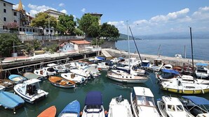 A marina with various boats docked, a building with a red roof, and a clear blue sky. - Apartment Josip by Interhome (Lovran/Tuliševica)