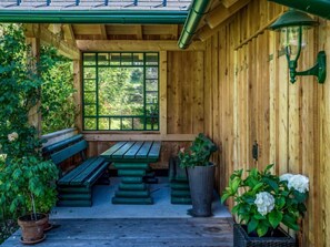 Relax in a cozy cabin-style room with a large window, wooden bench seating area, and potted plants.