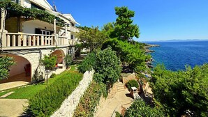A coastal property with a stone pathway, lush greenery, and a view of the sea. - Plavac Mali by Interhome (Trstenik/Dingač)