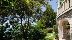 A garden with a stone pathway leading to an arched entrance. - Plavac Mali by Interhome (Trstenik/Dingač)