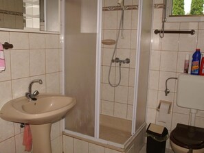 A bathroom with a sink, shower, toilet, and a mirror. - Vilma 2 by Interhome (Balatonmariafurdo)