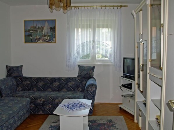 A living room with a sofa, a television, a cabinet, and a painting on the wall. - Vilma 2 by Interhome (Balatonmariafurdo)